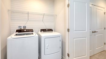 Two white front load washing machines in a laundry room at The Mark Townhomes Apartments, Harrisonburg, VA
